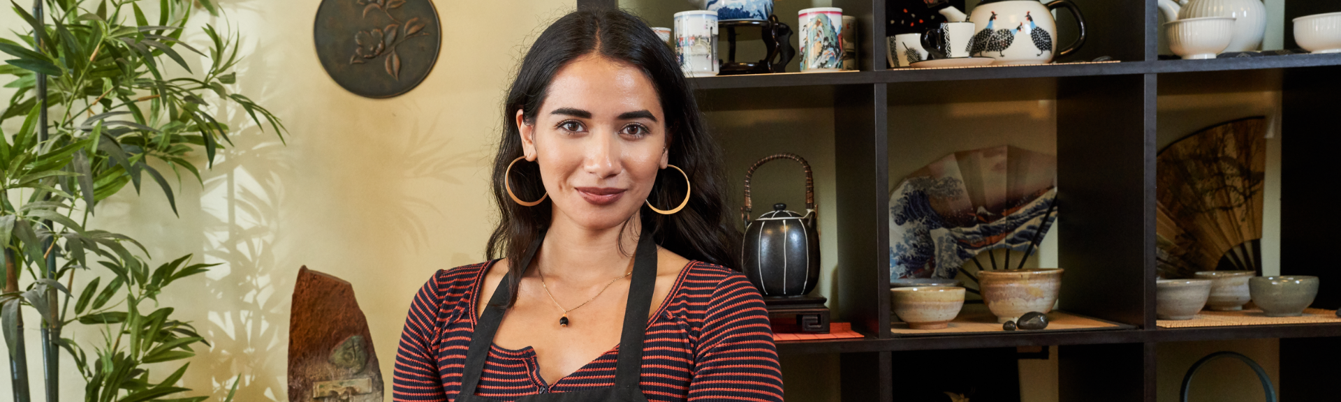 Woman smiling in apron at coffee shop